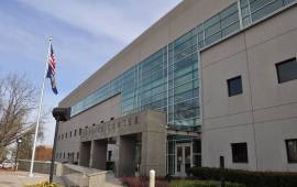 Photo of building with American flag, sign reads Justice Center