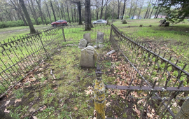 set of grave stones in a field surrounded by a fence