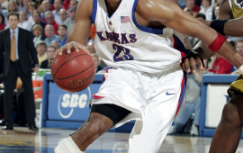Kansas Jayhawks basketball player Wayne Simien dribbles a basketball.