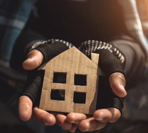 image of hands holding cardboard cutout of a house