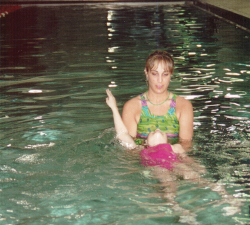 Parent with Child doing swim lessons at indoor pool