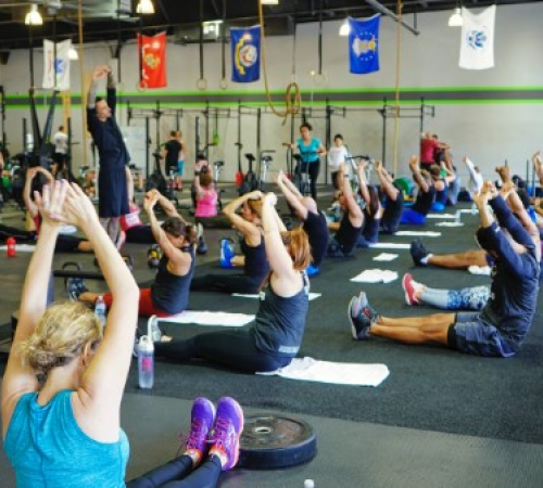 Women and men stretching and performing revelation poses during the fitness class