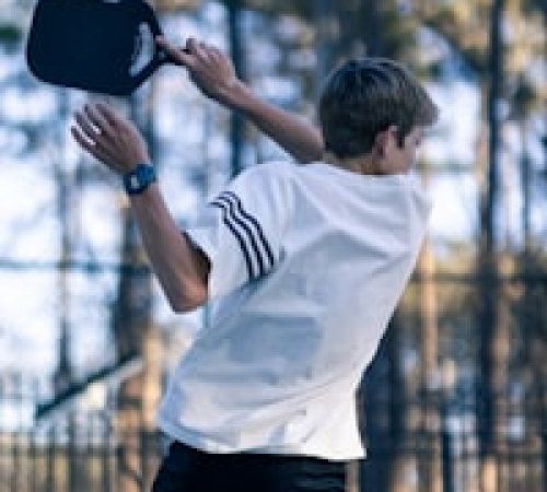 action shot of young pickleball player