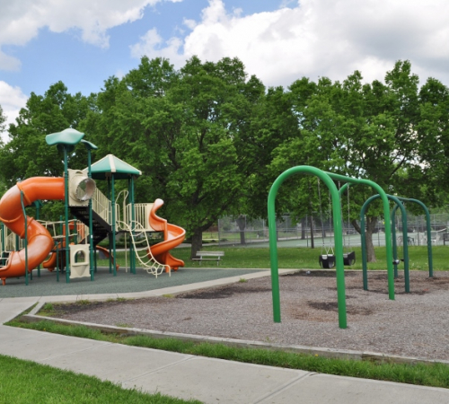 Playground equipment at David Brewer Park includes swings and a slide