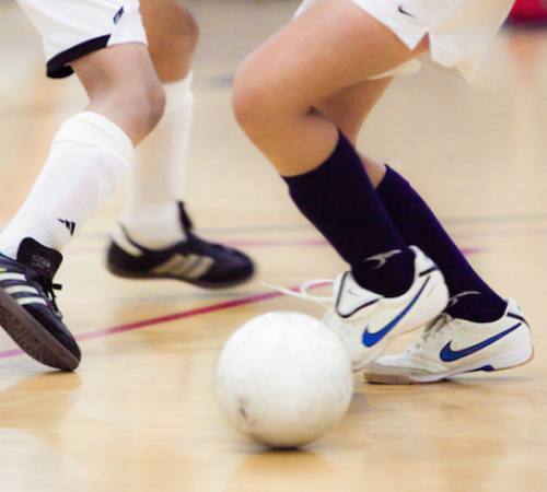 Two players feet kicking ball during futsal game in 2017