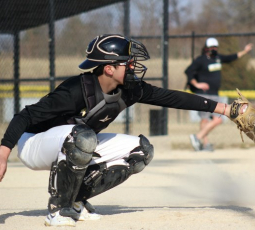 Picture of an adult male catching a ball at the plate playing softball