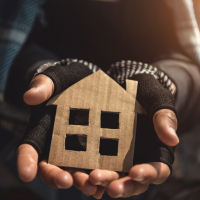 Housing Survey image of hands holding cardboard cutout of a house