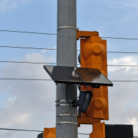 Photo shows a black panel mounted to a traffic safety light