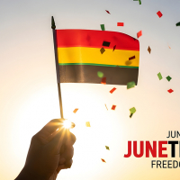 Juneteenth hand reaches for small flag with bands of red, yellow and green surrounded by confetti with text June 19 Juneteenth Freedom day