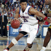 Kansas Jayhawks basketball player Wayne Simien dribbles a basketball.