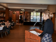 Leavenworth Mayor Holly Pittman addresses attendees at the Leavenworth Business Symposium in November 2025 Woman in black top and skirt speaks at podium to people seated at tables