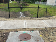 Storm Inlet with fence over looking storm ditch