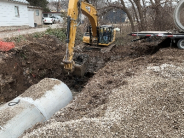 Image of construction workers adding fill dirt and gravel around new storm drain