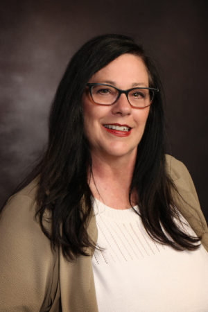 Woman with long black hair wearing light blouse and cardigan