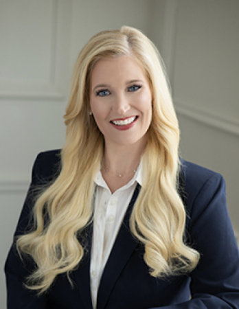 Photo of a woman with long blonde hair in a blazer.