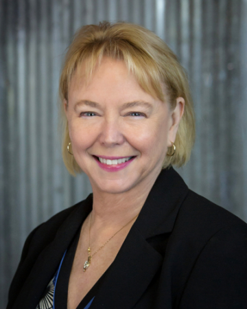 Photo of a woman with blonde hair wearing a black blazer.