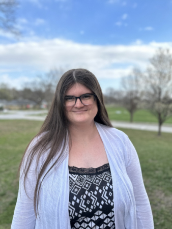 Photo of a woman with long brown hair and glasses.
