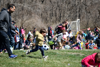 Large group of children running for to find Easter eggs in 2023