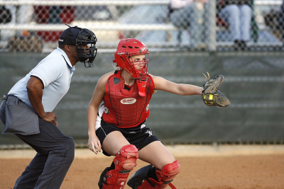 Picture of a plate umpire and a catcher playing coed softball
