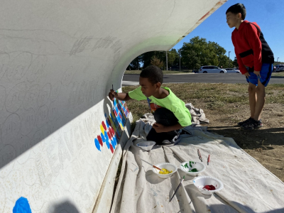 Boy painting on a snowplow blade