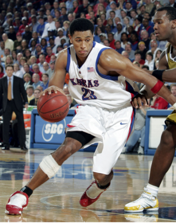 Kansas Jayhawks basketball player Wayne Simien dribbles a basketball.