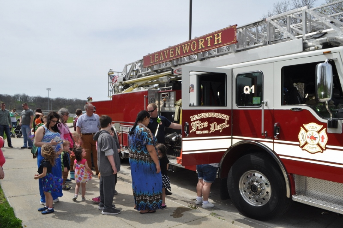 Community members lining up to see inside a Fire truck at a local park