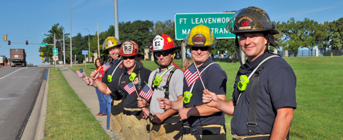 Firefighters wave flags Firefighters wave American flags along the highway