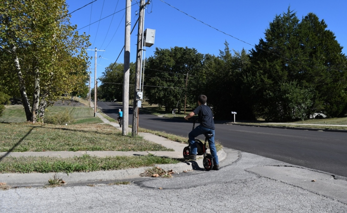 Child lifts bike over curb without ADA ramp Child lifts bike over curb without ADA ramp