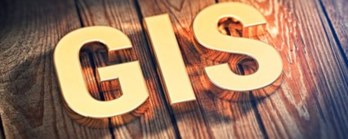 Geographical Information Systems Image of a yellow sign text above woodgrain with words GIS