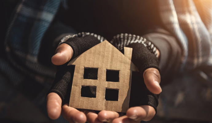 image of hands holding cardboard cutout of a house